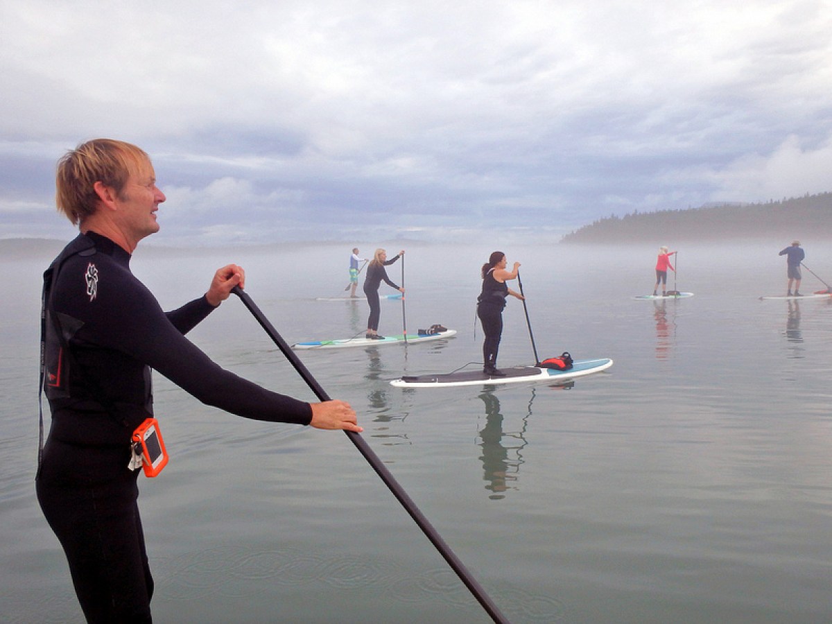 a group of people standing next to a body of water