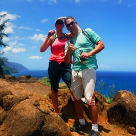 a man and a woman standing on a rocky beach