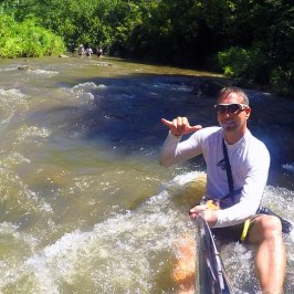 a man riding on the back of a boat in the water
