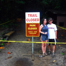 a young boy standing in front of a sign