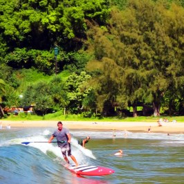 a man riding on the back of a boat in the water