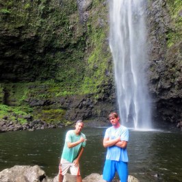a man standing next to a waterfall
