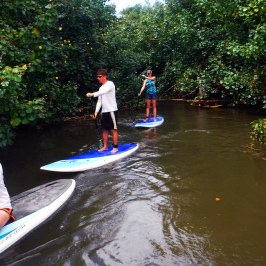 a group of people riding on the back of a boat in the water