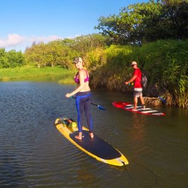 a group of people riding on the back of a boat in the water