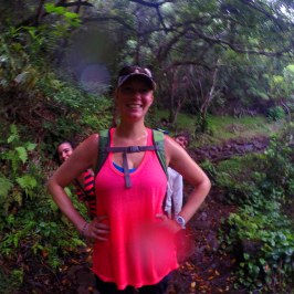 a woman in a red dress standing in front of a forest
