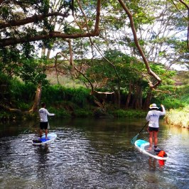 a group of people riding on the back of a boat in the water