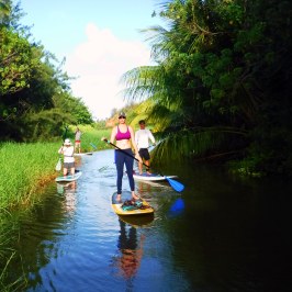 a little girl riding on the back of a boat in the water