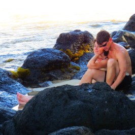 a person sitting on a rock next to water