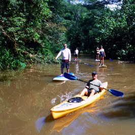 a group of people riding on the back of a boat in the water