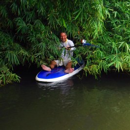 a man riding on the back of a boat in the water
