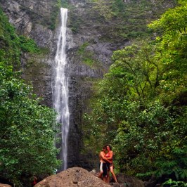 a man standing next to a waterfall