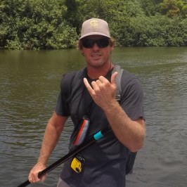 a man standing next to a body of water