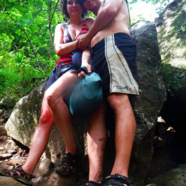a woman sitting on a rock talking on a cell phone