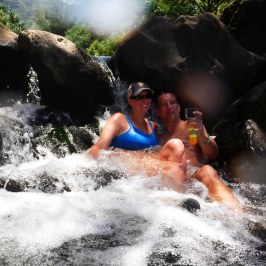 a young girl riding a wave on top of a body of water
