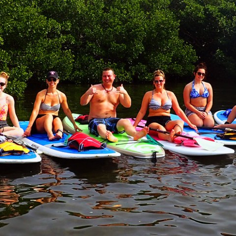 a group of people riding on the back of a boat in the water