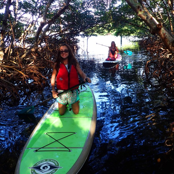a young girl riding a wave on a surfboard in the water