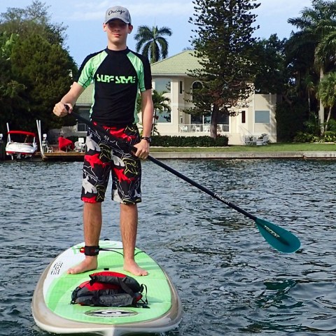 a man riding on the back of a boat in the water