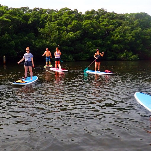 a group of people riding on the back of a boat in the water