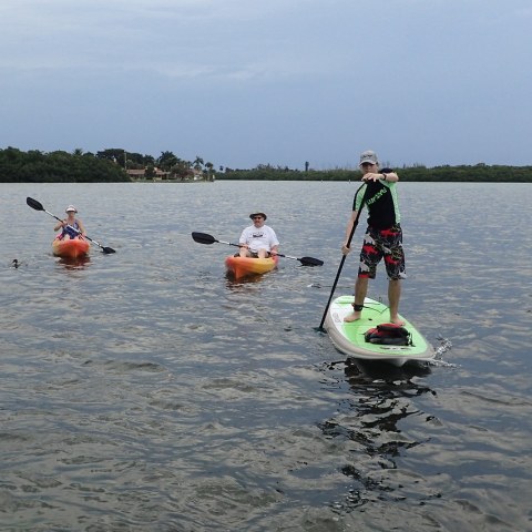 a group of people riding on the back of a boat in the water