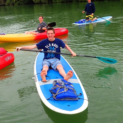 a group of people rowing a boat in the water