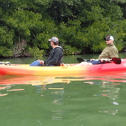a man riding on the back of a boat in the water