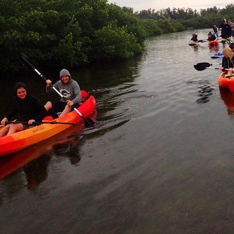 a group of people riding on the back of a boat in the water