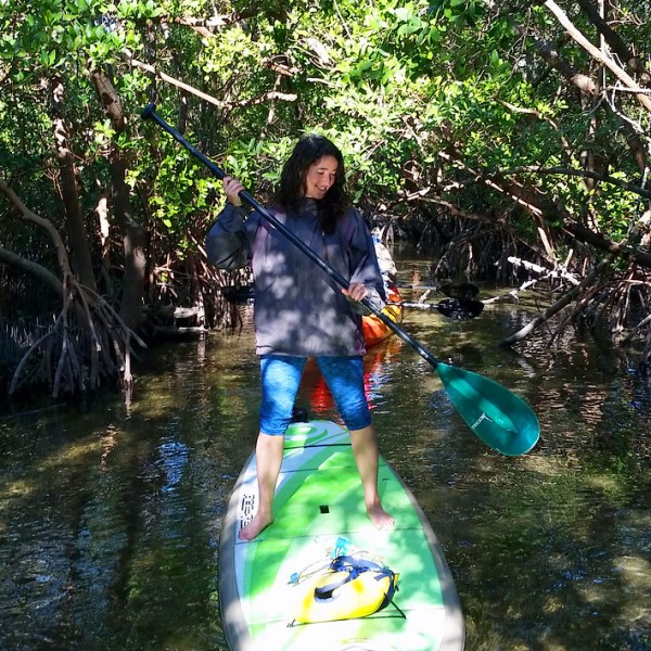 a little girl standing in front of a lake
