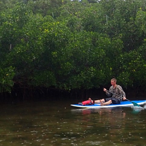 a man riding on the back of a boat in the water