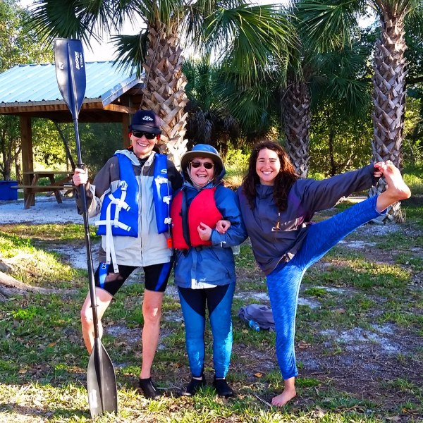 a group of people standing next to a tree