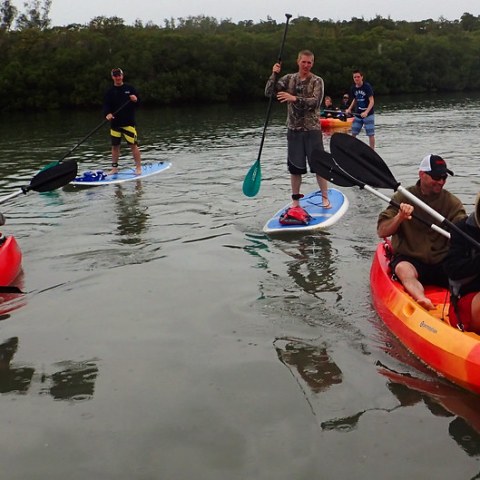 a group of people in a small boat in a body of water