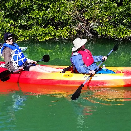 a group of people riding on the back of a boat in the water