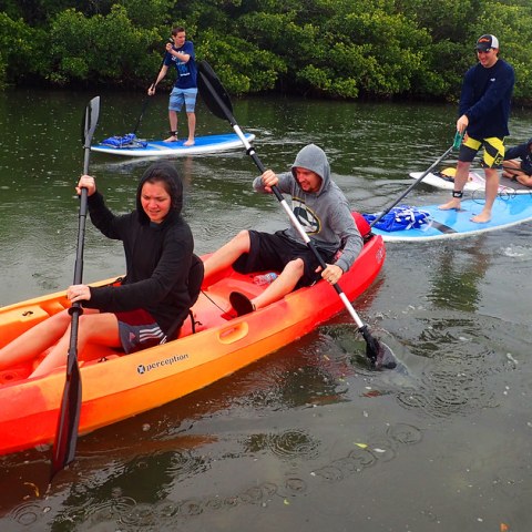 a group of people riding on the back of a boat in the water