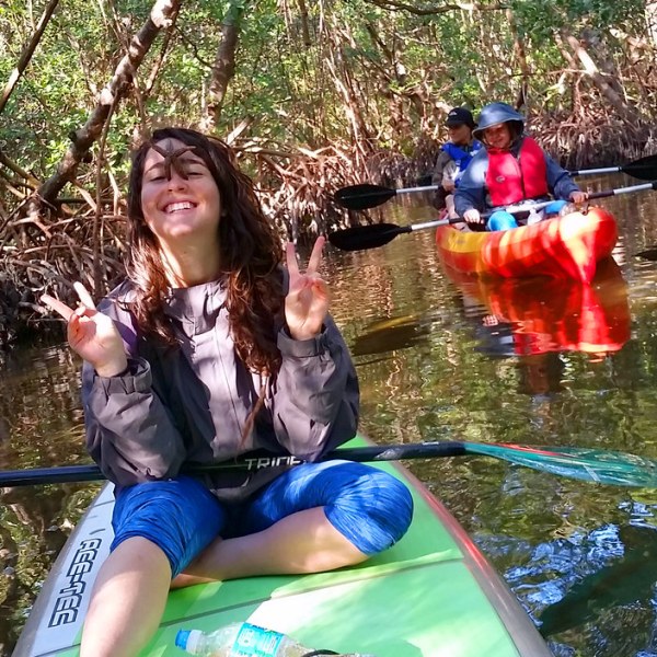a woman sitting next to a river