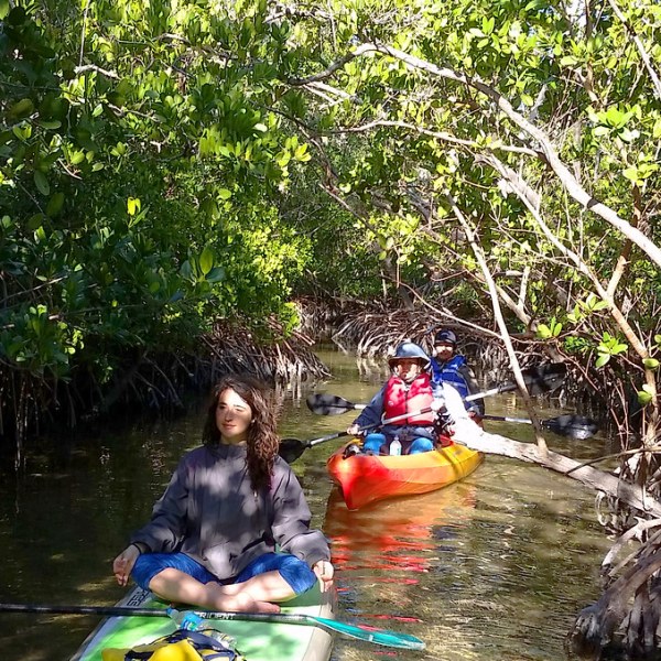 a group of people riding on the back of a boat in the water