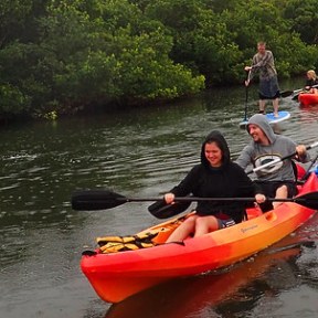 a group of people riding on the back of a boat in the water