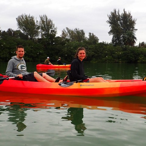 a man riding on the back of a red boat on the water
