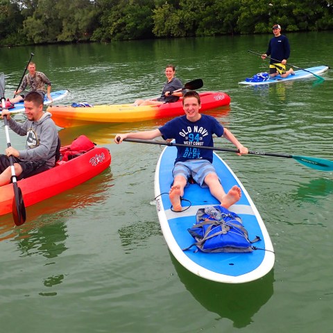 a group of people riding on the back of a boat in the water