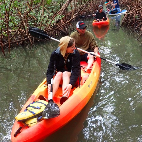 a group of people riding on the back of a boat in the water