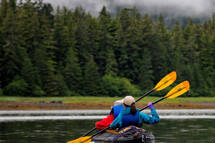 a person riding on the back of a boat in a body of water